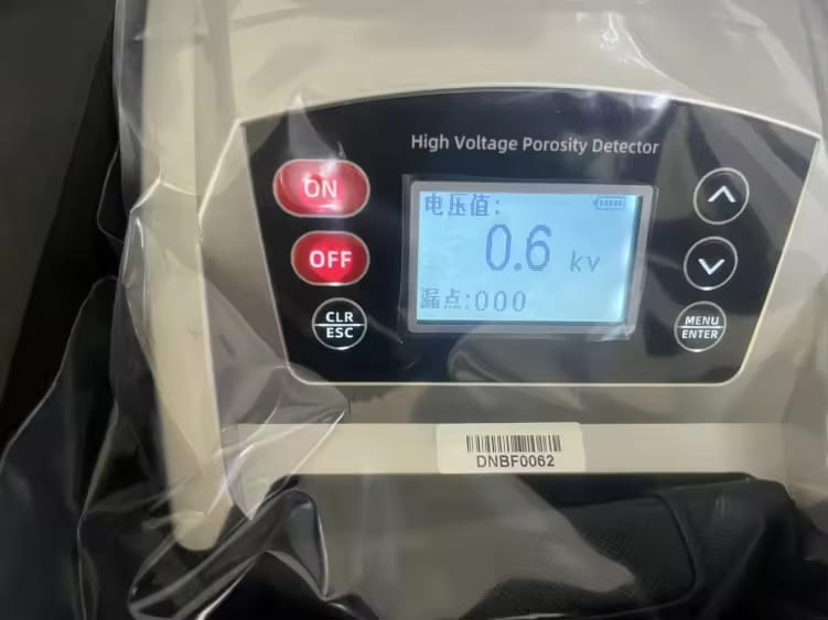 High-voltage holiday detector with complete inspection accessories for non-destructive coating testing applications.
