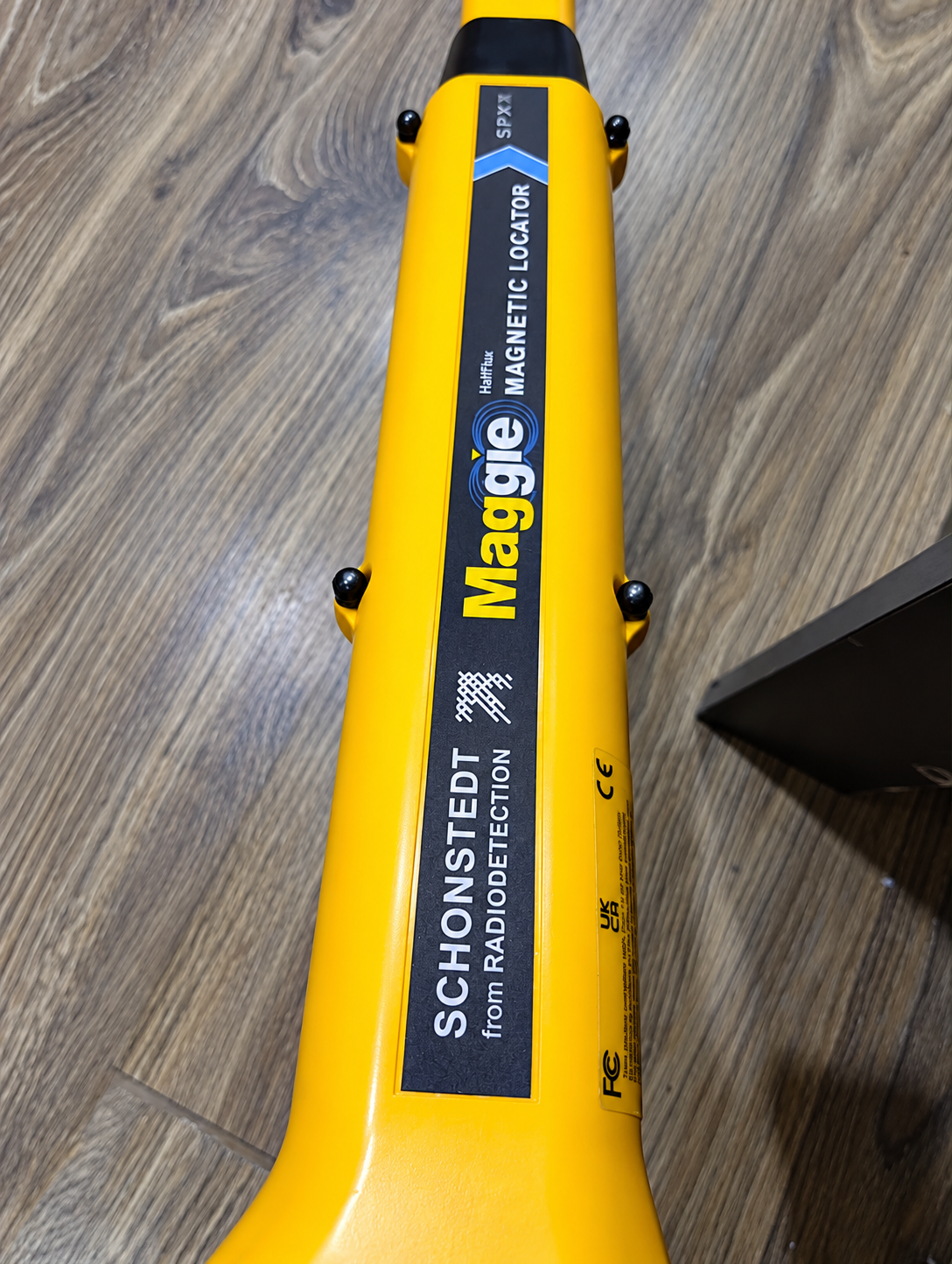 Yellow Maggie Magnetic Locator on Wood Floor